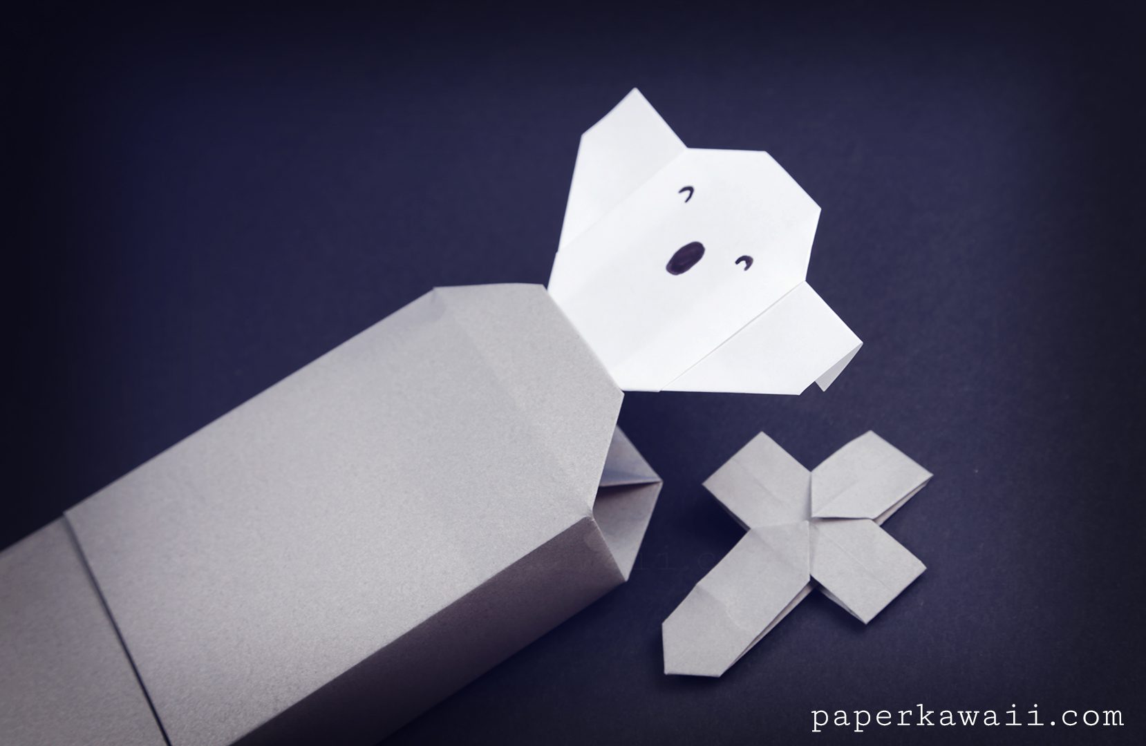 A cute origami ghost coming out of an origami tombstone box!